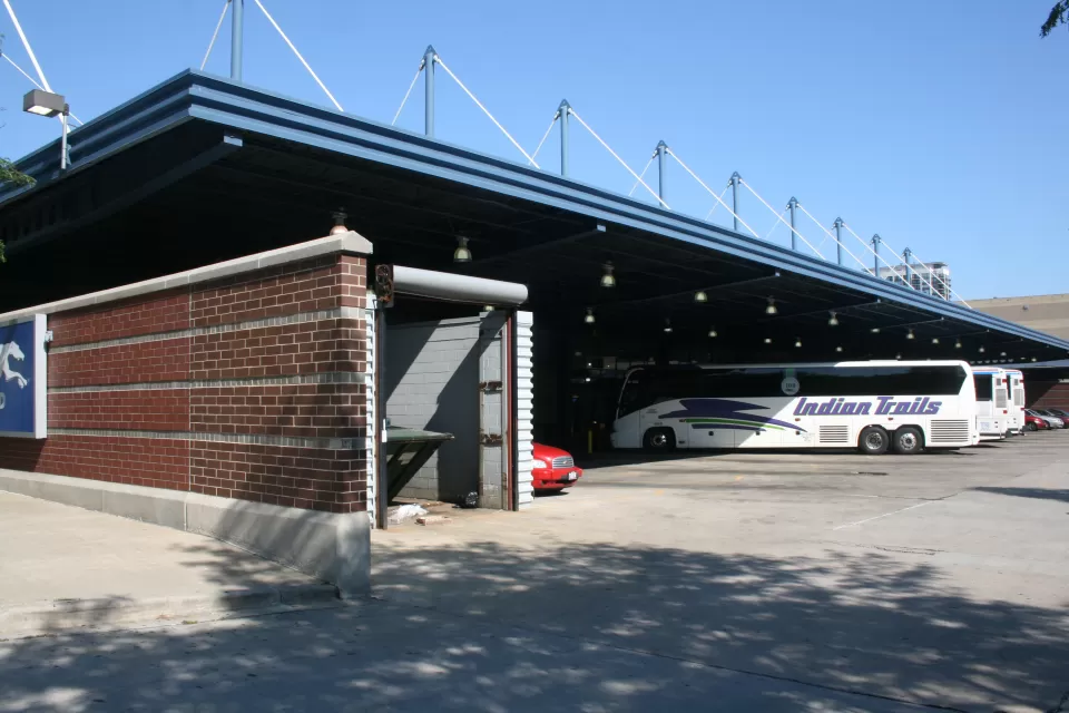 Covered carport area for buses at Chicago Greyhound station with one white Greyhound bus parked